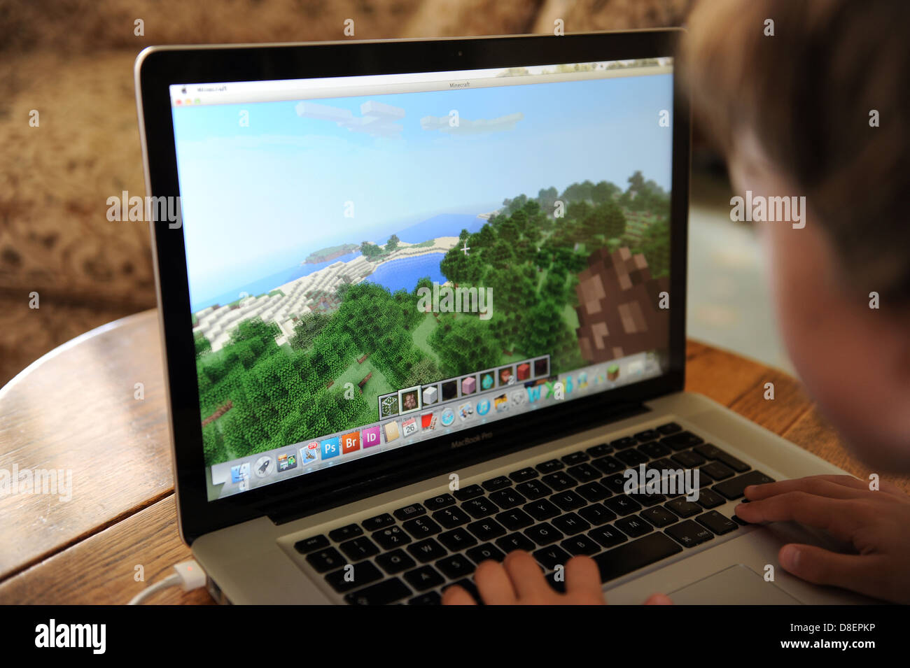 An 8 year old boy playing minecraft on his computer Apple IPAD in his ...