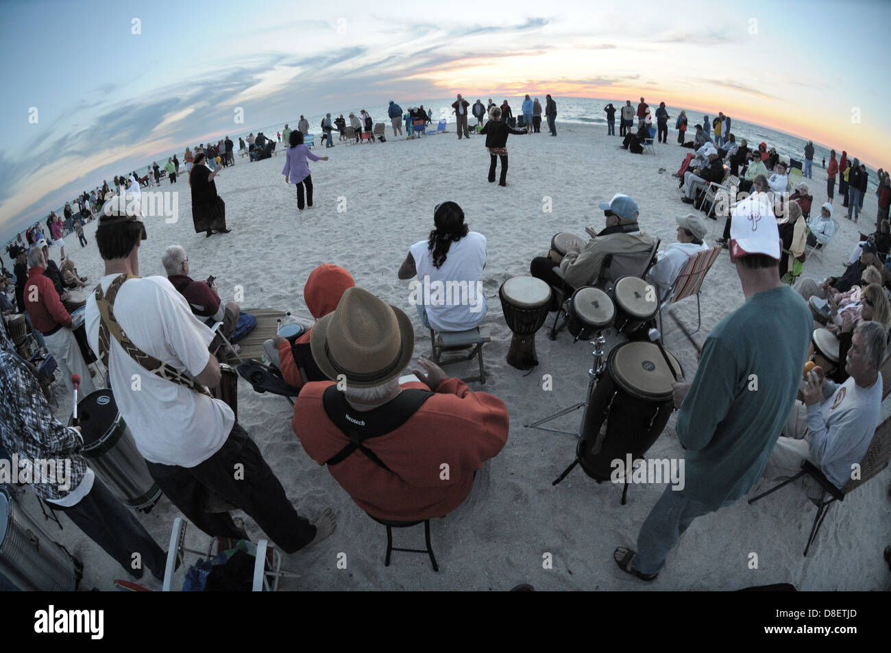 A group gathers on Nokomis, Florida beach to play drums as the sun sets as part of the drum circle. Stock Photo