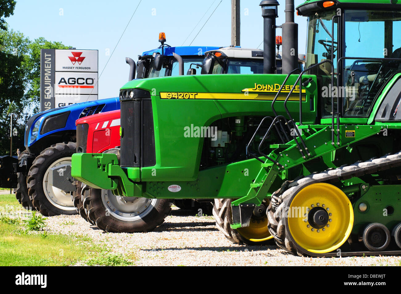 three farm tractors made by John Deere, Massey Ferguson and New Holland