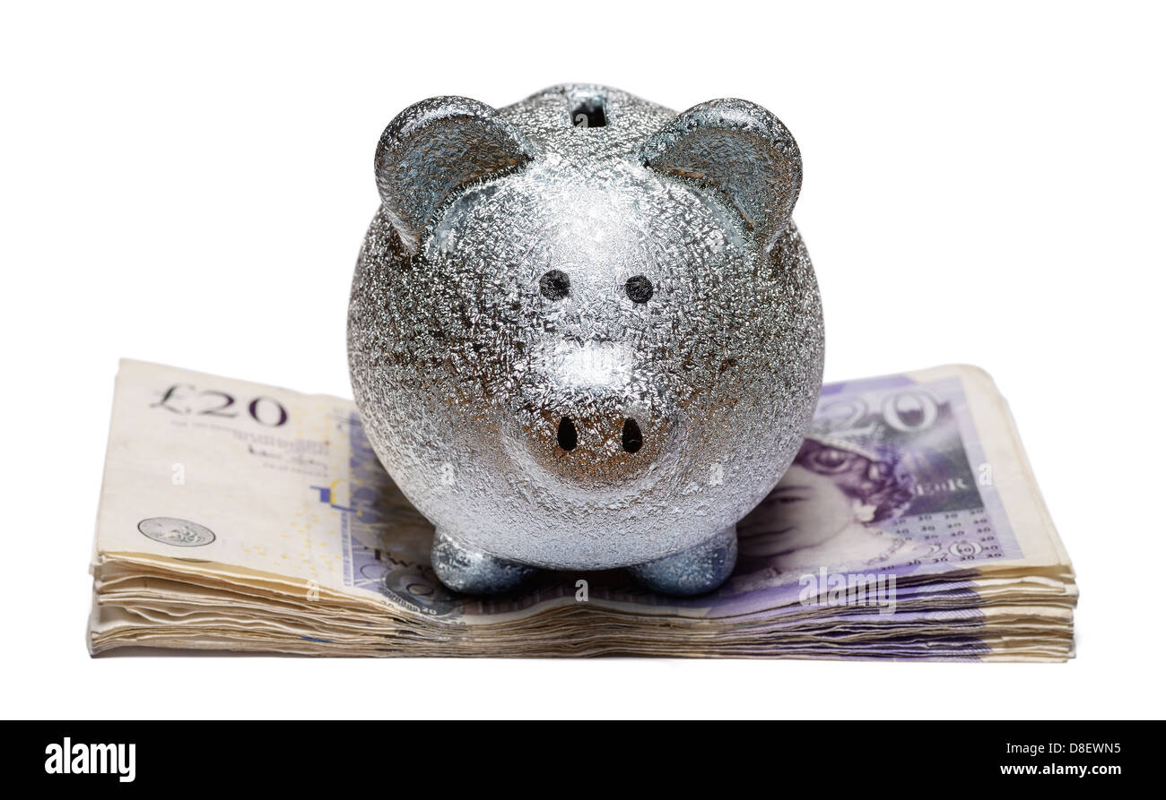Piggy bang on a pile of twenty pound notes Stock Photo