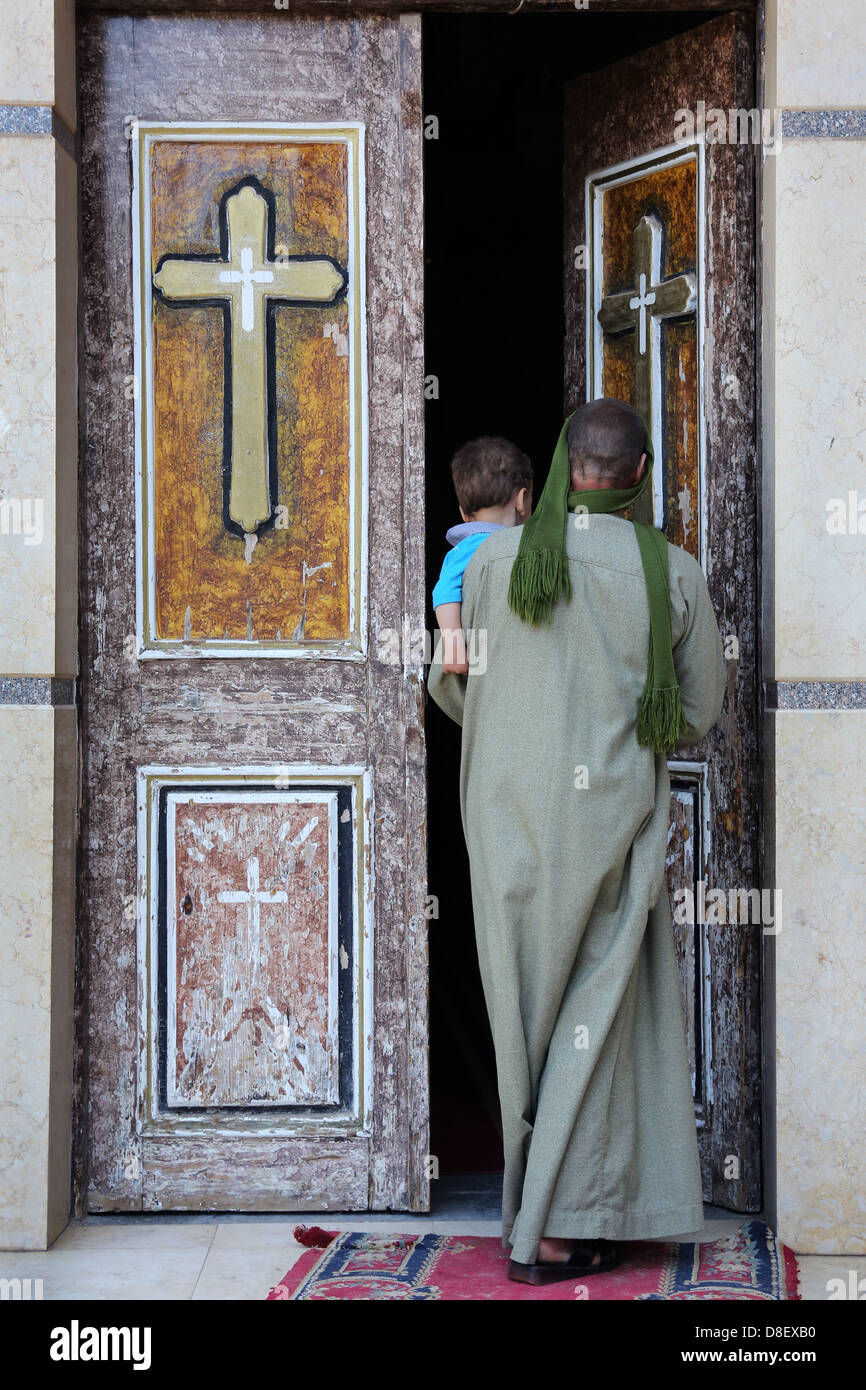 man and child entering catholic coptic christian church in Al Ghanayem church, diocese of Asyut, Egypt Stock Photo