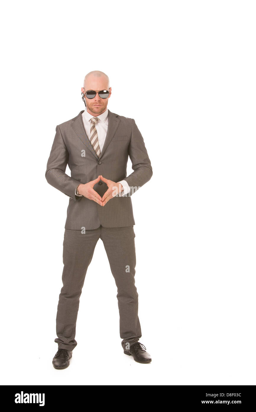 Serious and menacing male security-staff wearing sunglasses in a power position, isolated on a white background Stock Photo