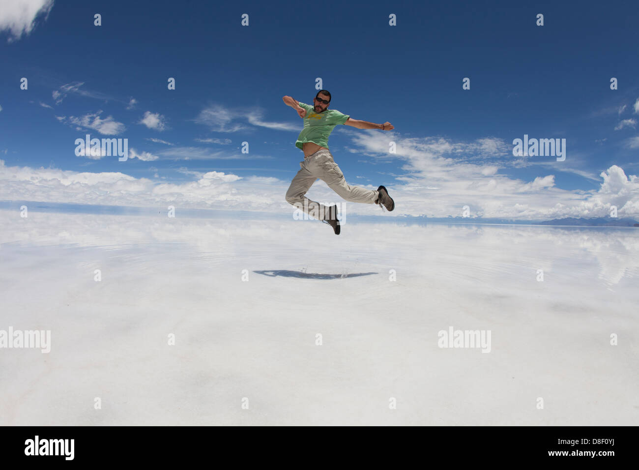 Man jumps and twists in mid air at Salar de Uyuni Stock Photo