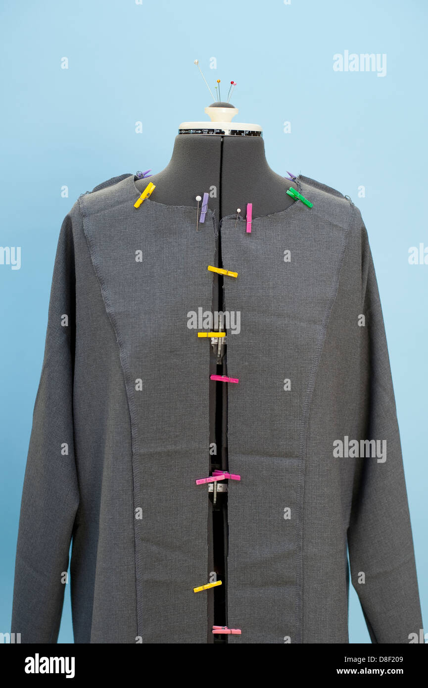 Dress maker form mannequin with colorful clothes pins holding jacket