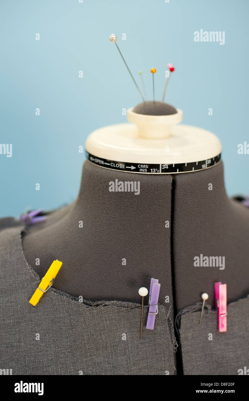 Dress maker form mannequin with colorful clothes pins holding jacket