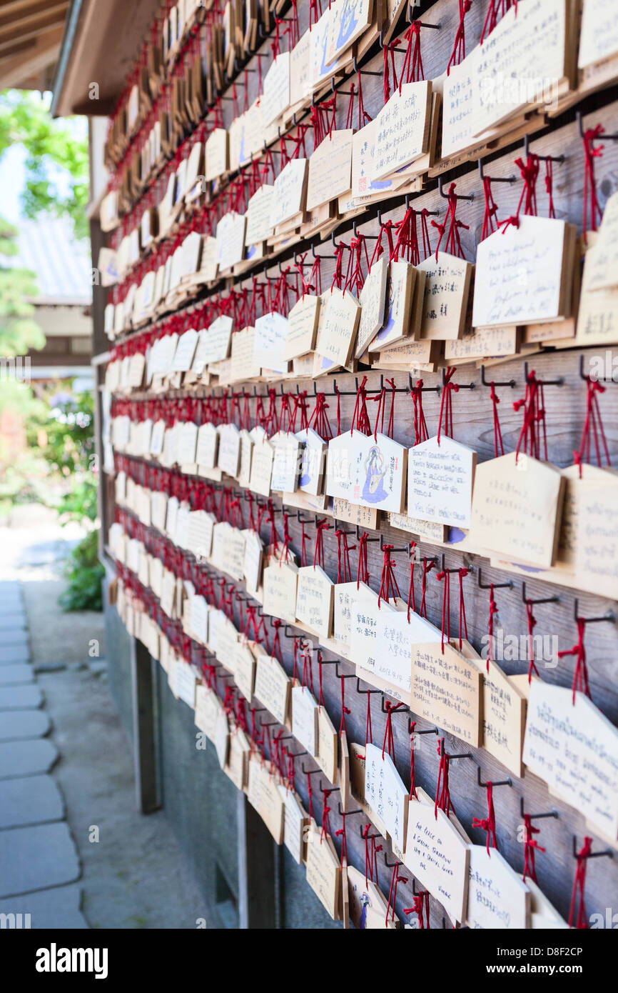 Ema are on the wall - small wooden plaques on which Shinto worshippers write their prayers or wishes. Kamakura, Japan Stock Photo