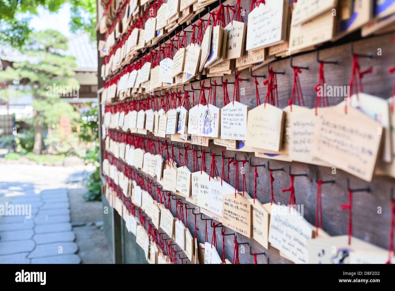 Ema are on the shrine wall small wooden plaques on which Shinto worshippers write their prayers or wishes. Kamakura, Japan Stock Photo