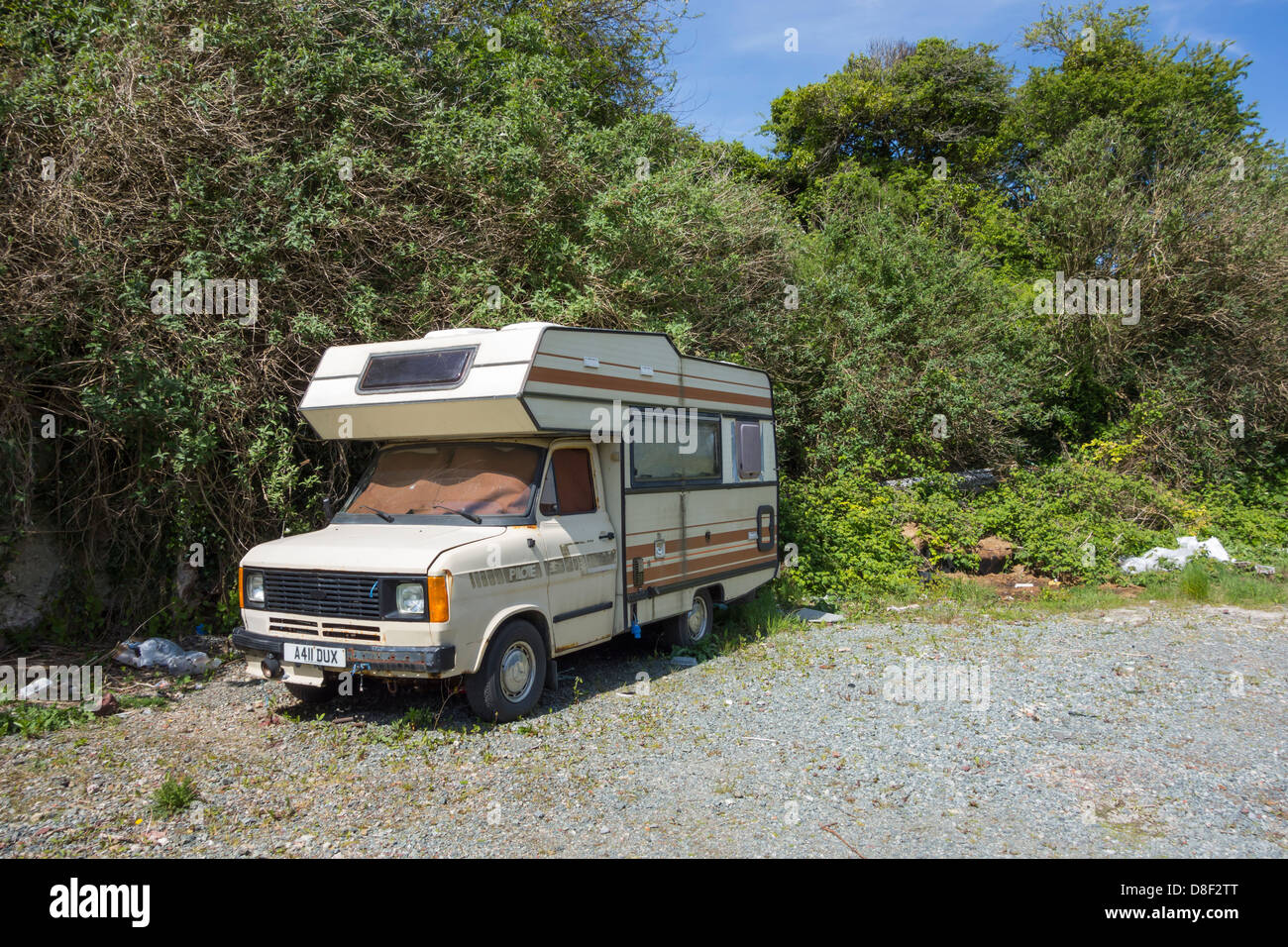 An abandoned motor home which has been vandalized at the roadside. Stock Photo