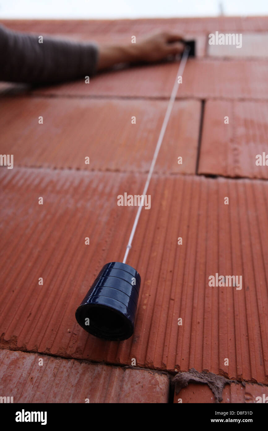 Bricklayer using a plumb line Stock Photo Alamy