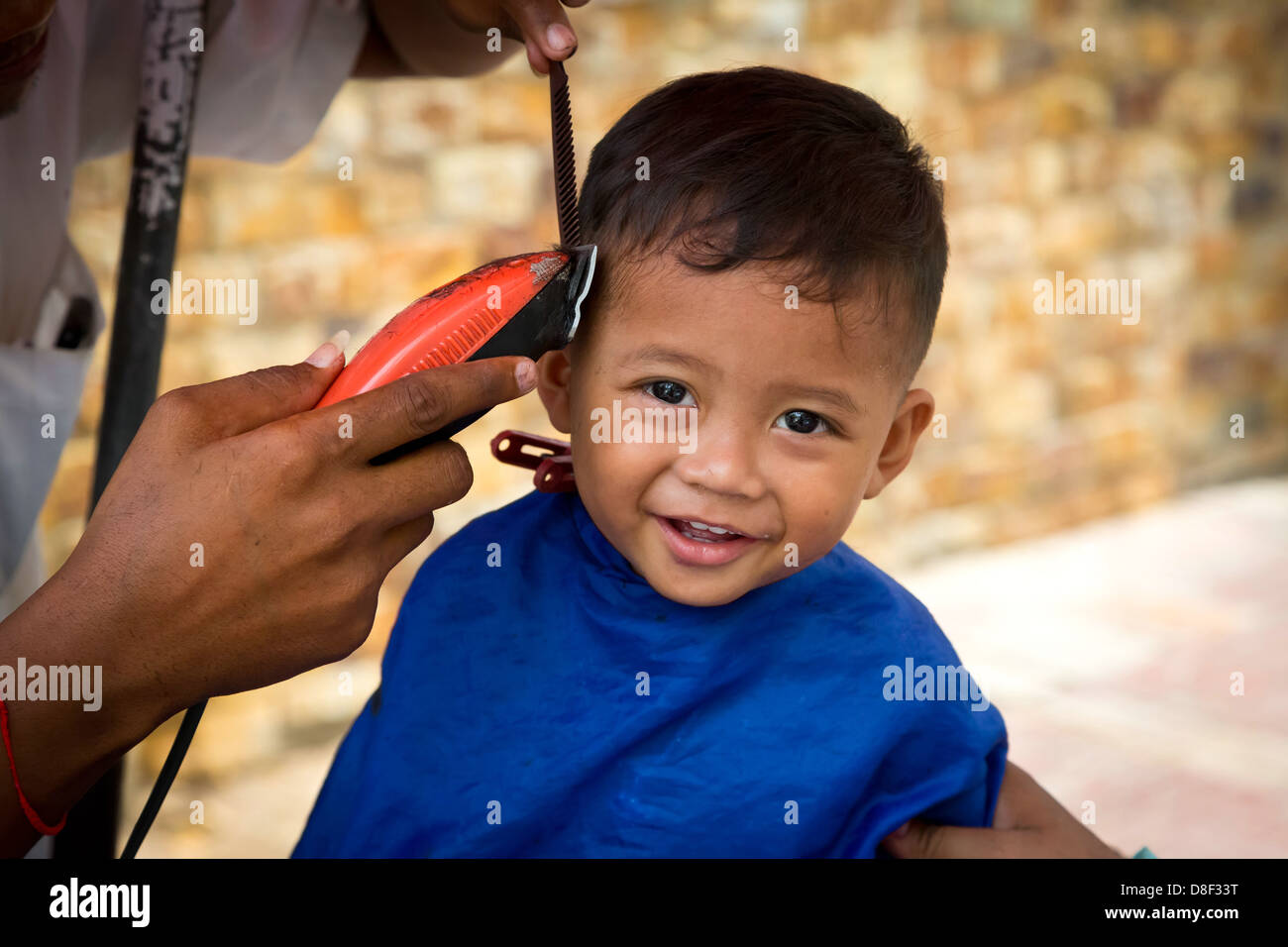 Little Boy getting a Haircut in the Streets of Phnom Penh, Cambodia Stock Photo