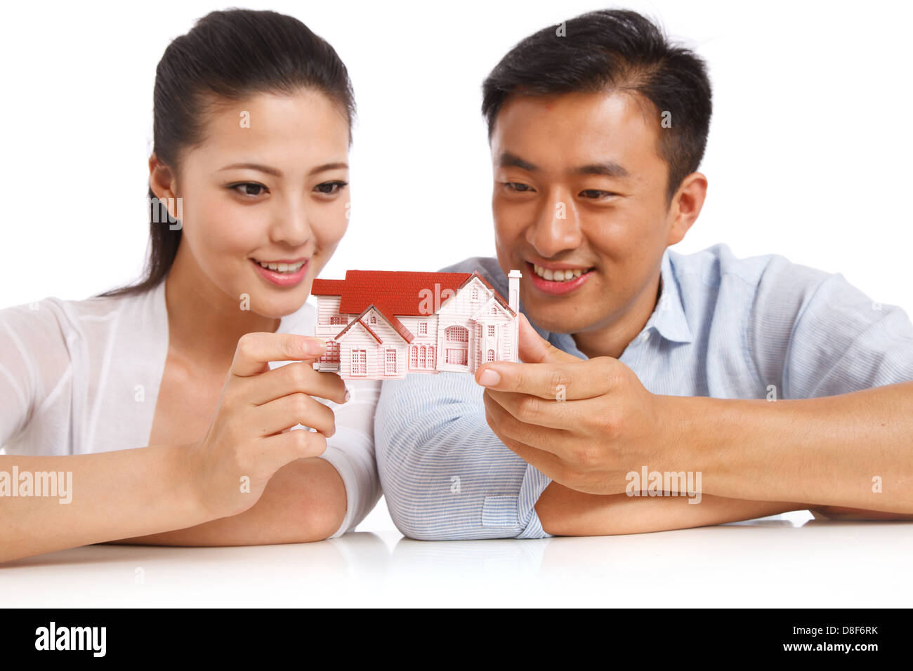 Young couple holding house model Stock Photo - Alamy