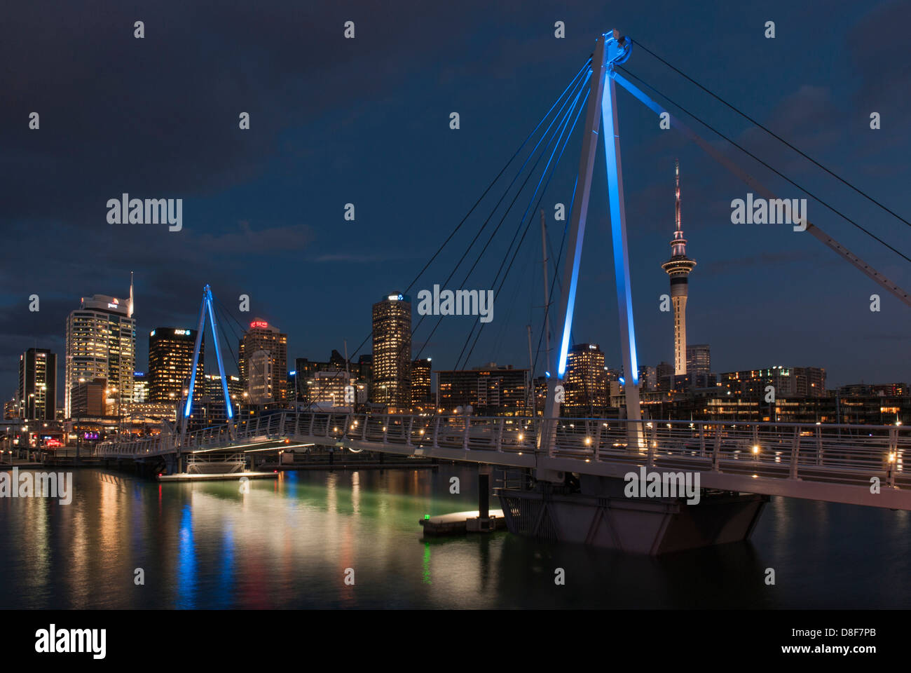 Wynyard Crossing, the lifting bridge between Wynyard Quarter and Viaduct Marina, downtown Auckland CBD and Sky Tower in background, early evening. Stock Photo