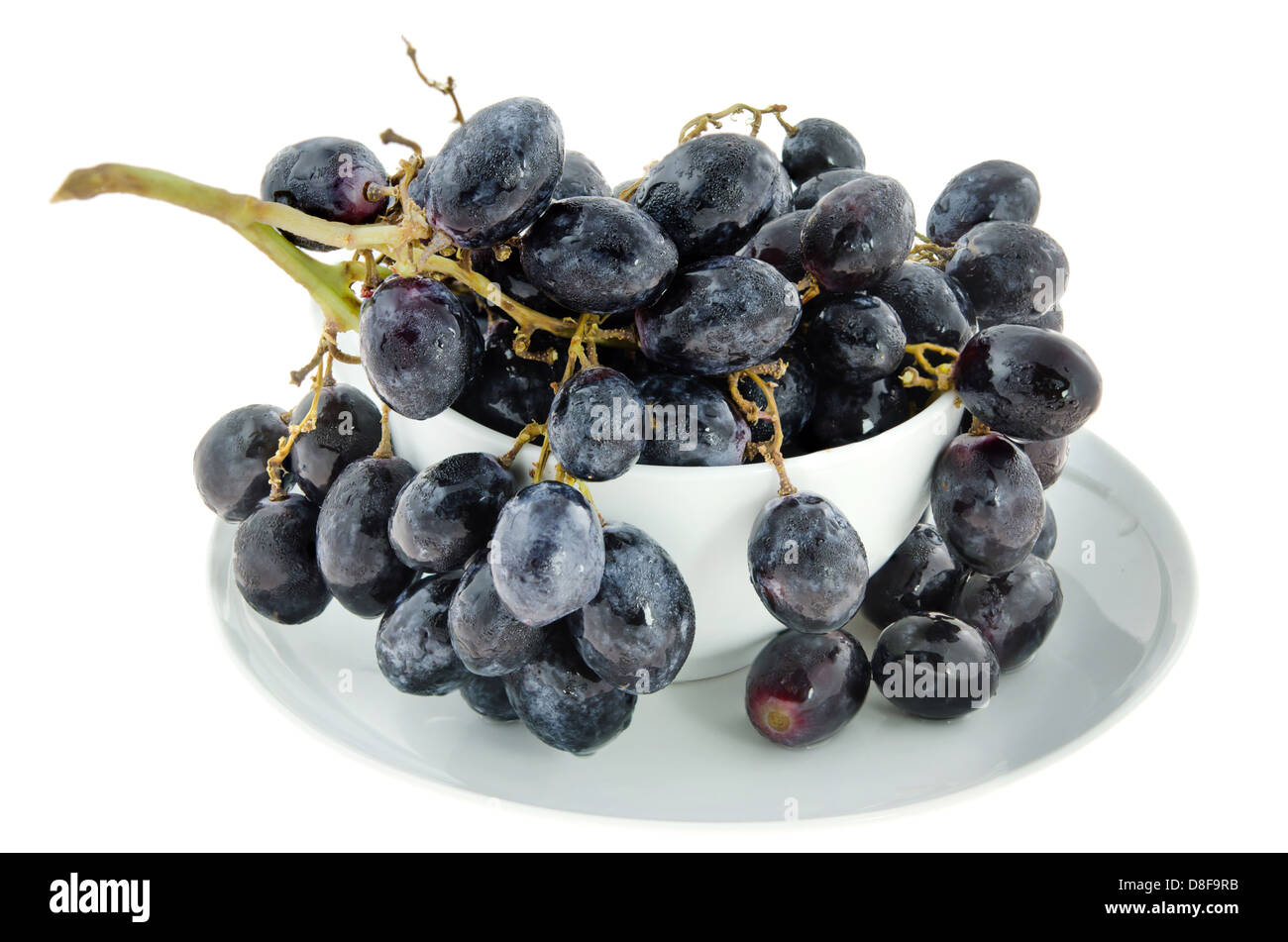 ripe grapes fruits in white bowl over white background Stock Photo