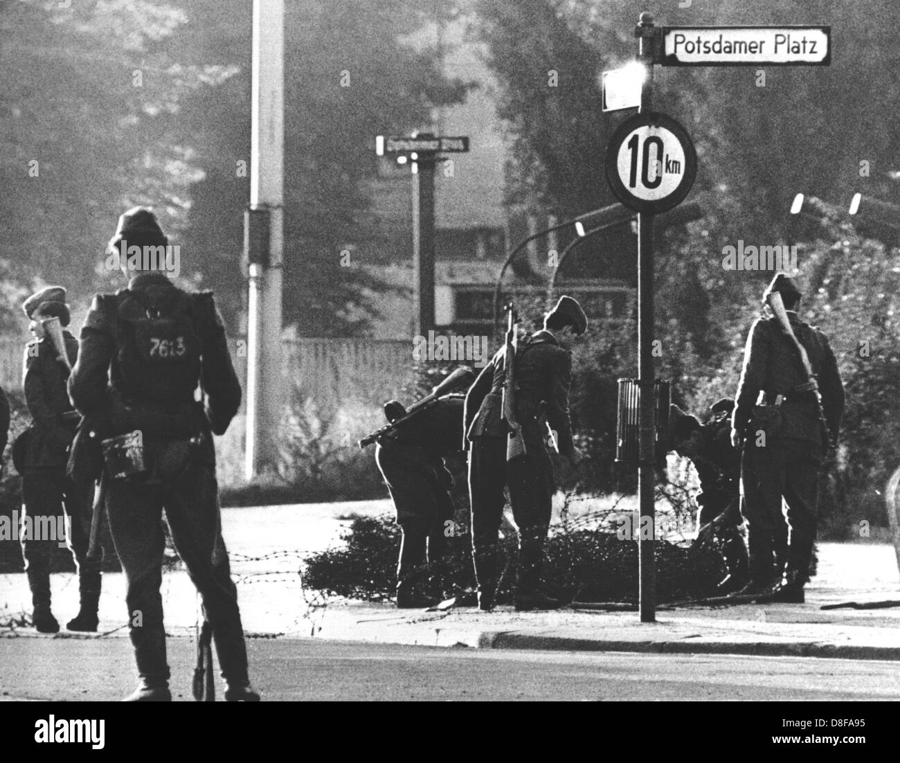 Volkspolizisten beim Errichten von Stacheldrahtsperren am Potsdamer Platz. Am frühen Sonntagmorgen des 13. August 1961 wurde unter der Aufsicht von bewaffneten Streitkräften der DDR mit der Errichtung von Straßensperren aus Stacheldraht und dem Bau einer Mauer begonnen, um den Ostteil Berlins vom Westteil abzusperren. Die Mauer soll den ständig steigenden Flüchtlingsstrom von Ost- nach West-Berlin stoppen. Stock Photo