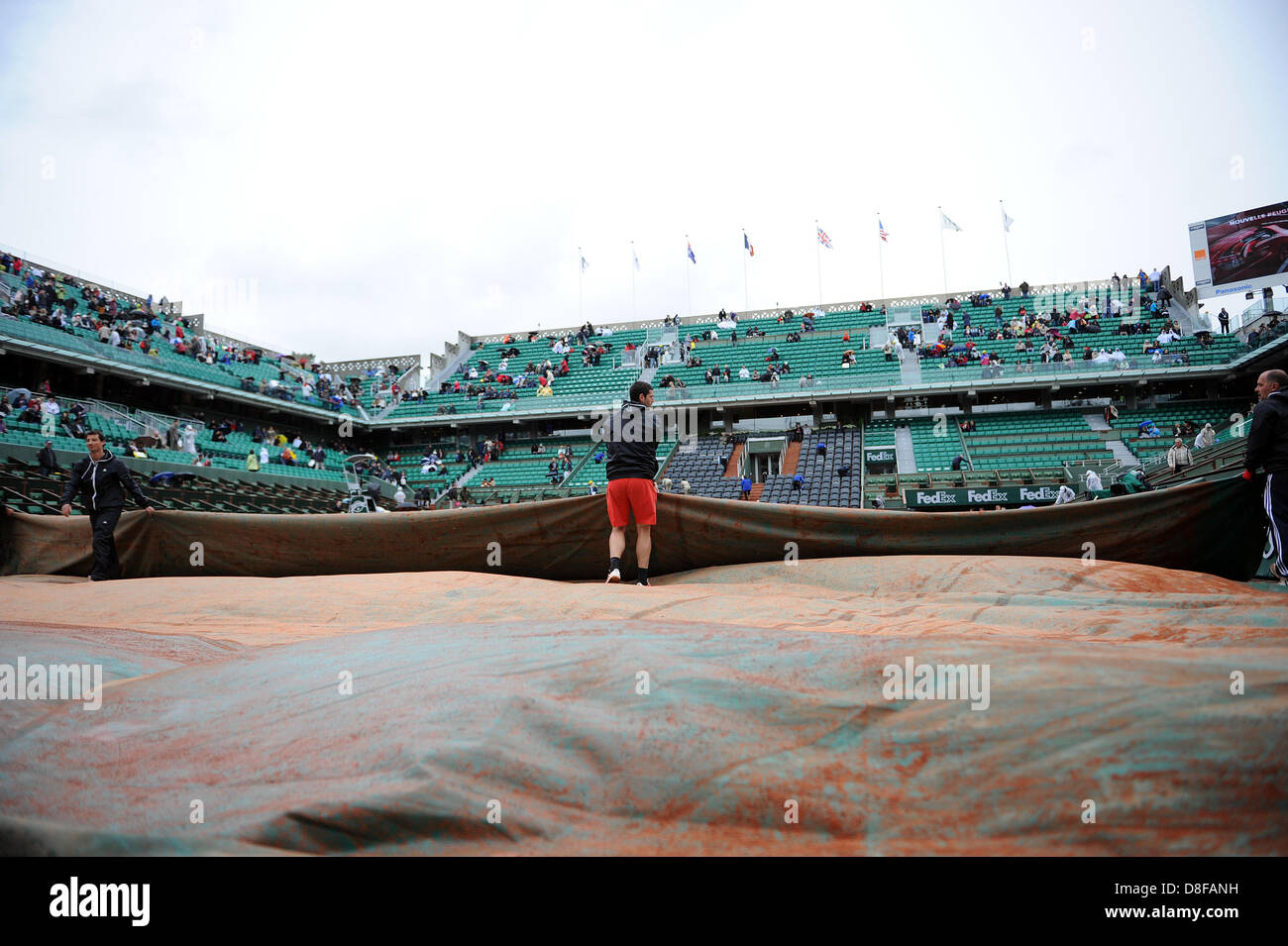 Paris, France. 28th May 2013. Groundstaff fold the covers back on court Philippe Chatrier to prepare for the first round of the French Open from Roland Garros. Credit: Action Plus Sports Images/Alamy Live News Stock Photo