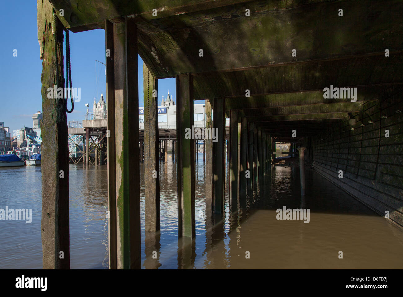 HMS President jetty seen from Thames foreshore, Tower Bridge in distance Stock Photo