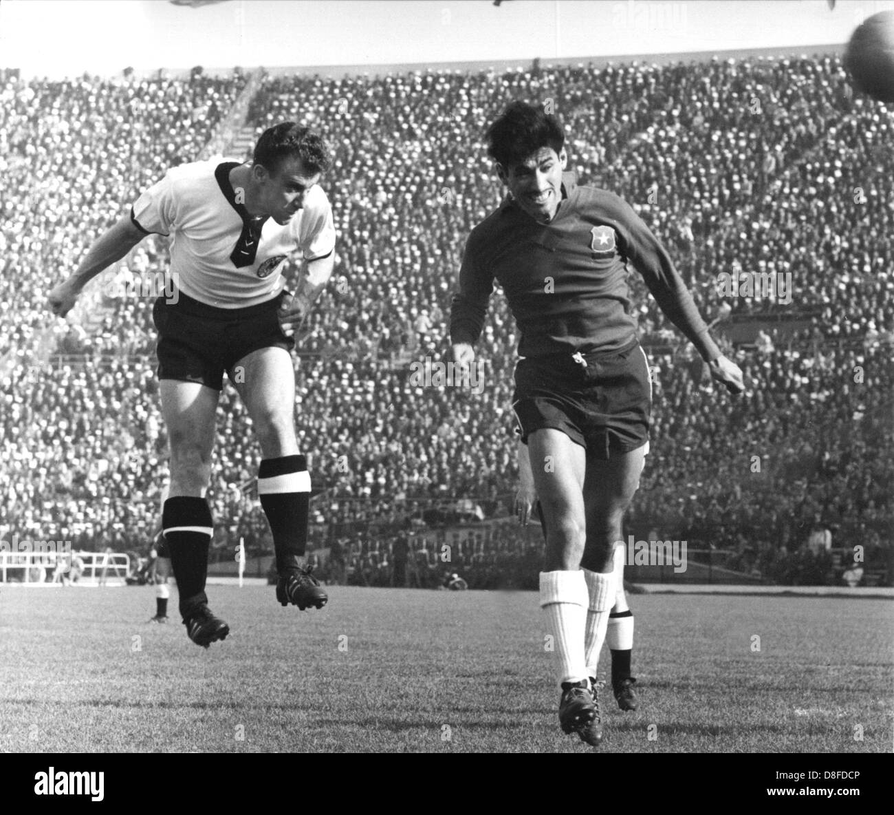 Hans Schaefer (left) and Chilean Landa duel for the ball. Germany beat the heavily favoured Chilean team during the 1962 World Cup preliminary round game at the  Stadion Nacional in Santiago de Chile, Chile on 6 June 1962. The first German goal came in the 21st minute on a penalty shot by Szymaniak after a foul on Uwe Seeler and in the 81st minute Seeler himself scored the 2-0 with a header. Chile finished second in the group, Italy and Switzerland were eliminated from the competition. Stock Photo