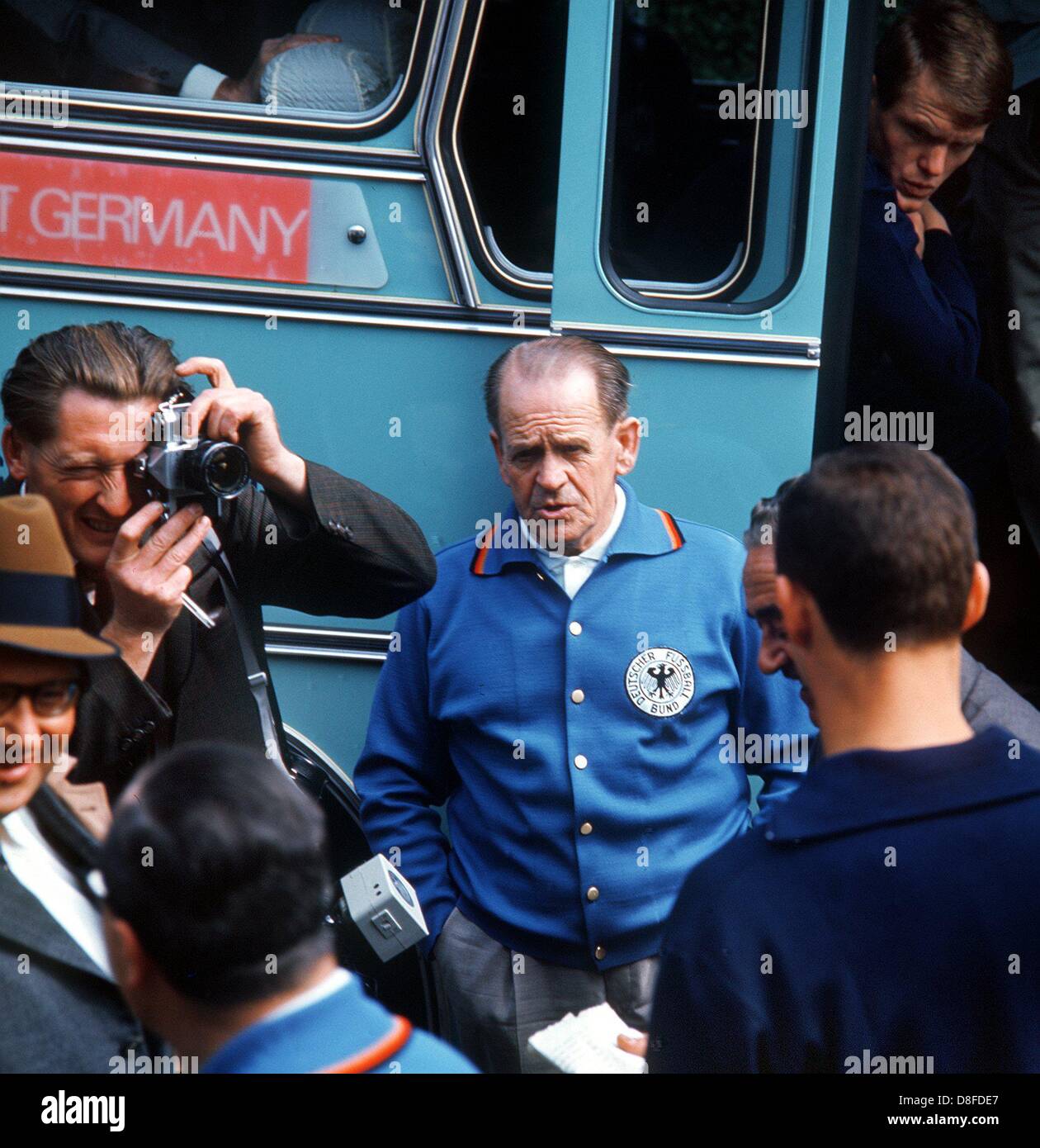 German national team coach Sepp Herberger (centre) standing next to the team bus just before leaving for a practice session during the 1966 World Cup in England. (undated file photo) Stock Photo