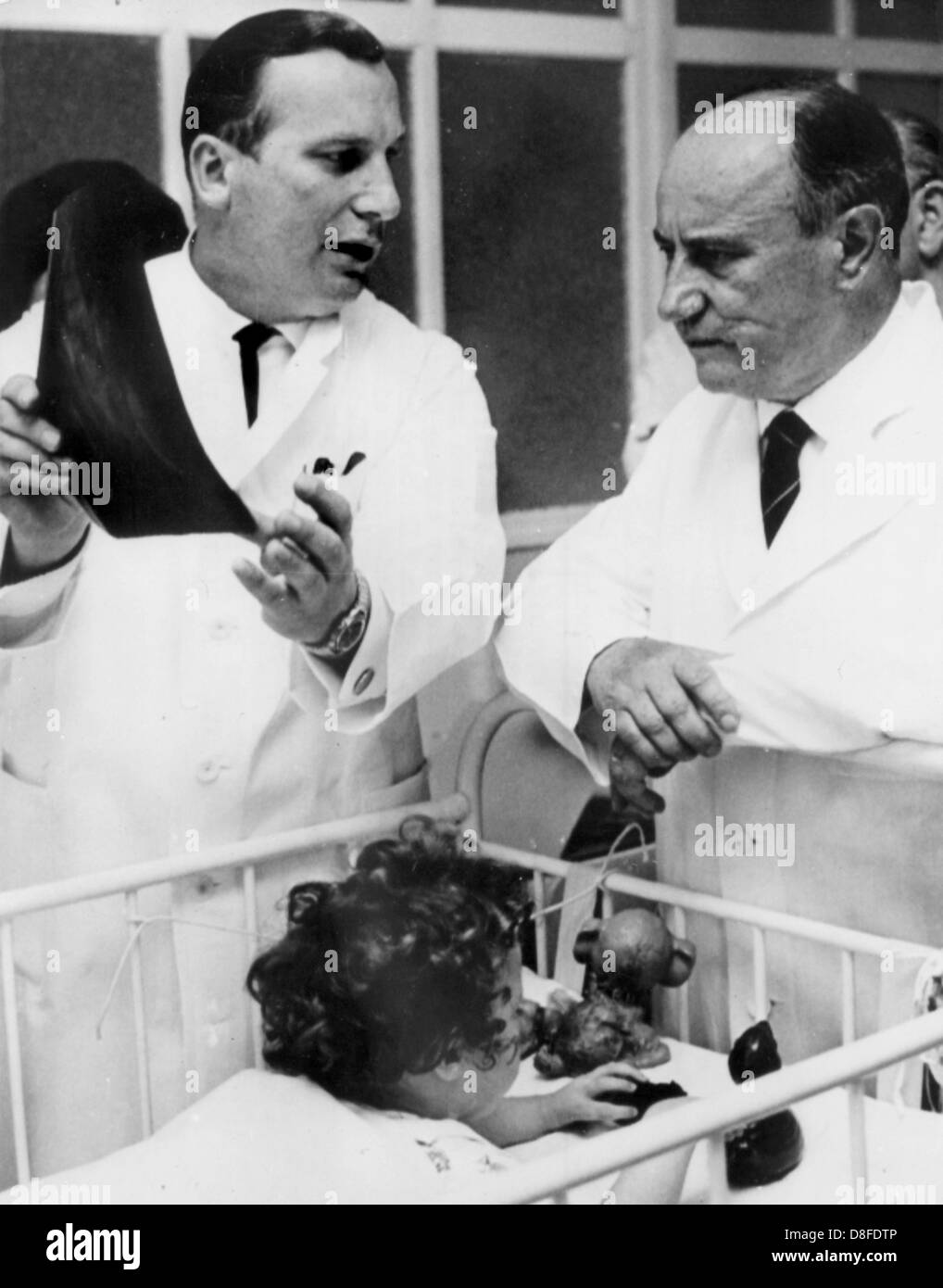 Georg Diederichs (r), prime minister of the German state of Lower Saxony, visits the 'Anna-Stift' hospital in Hanover, Germany, 17 September 1963. The hospital offers therapies for children with severe physical disabilities. In the dysmelia ward, which was opened earlier that year, up to 30 Contergan affected children are treated as inpatients. On the left the hospital's head physician, Professor Dr. Gustav Hauberg, can be seen. Stock Photo