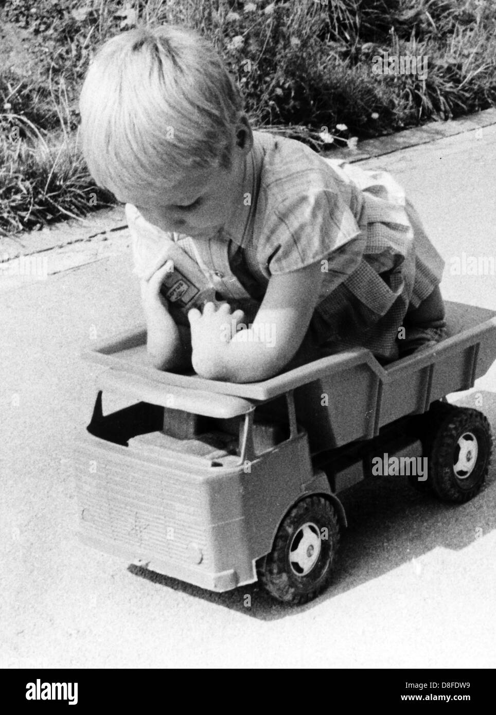 The handicapped daughter of the Härdrich couple from Stollberg (near Aachen), Germany, plays with toy truck in a picture dated August 1968. The Härdrichs had caused a stir on 20 August 1968 with an unusual offer to prove that the Contergan drug causes deformities in children. The 40-year-old woman suggested that she take Contergan again during another pregnancy. The couple, which was a joint plaintiff at the Contergan trial, was ready to provide themselves for a procedure under strict scientific supervision. Stock Photo