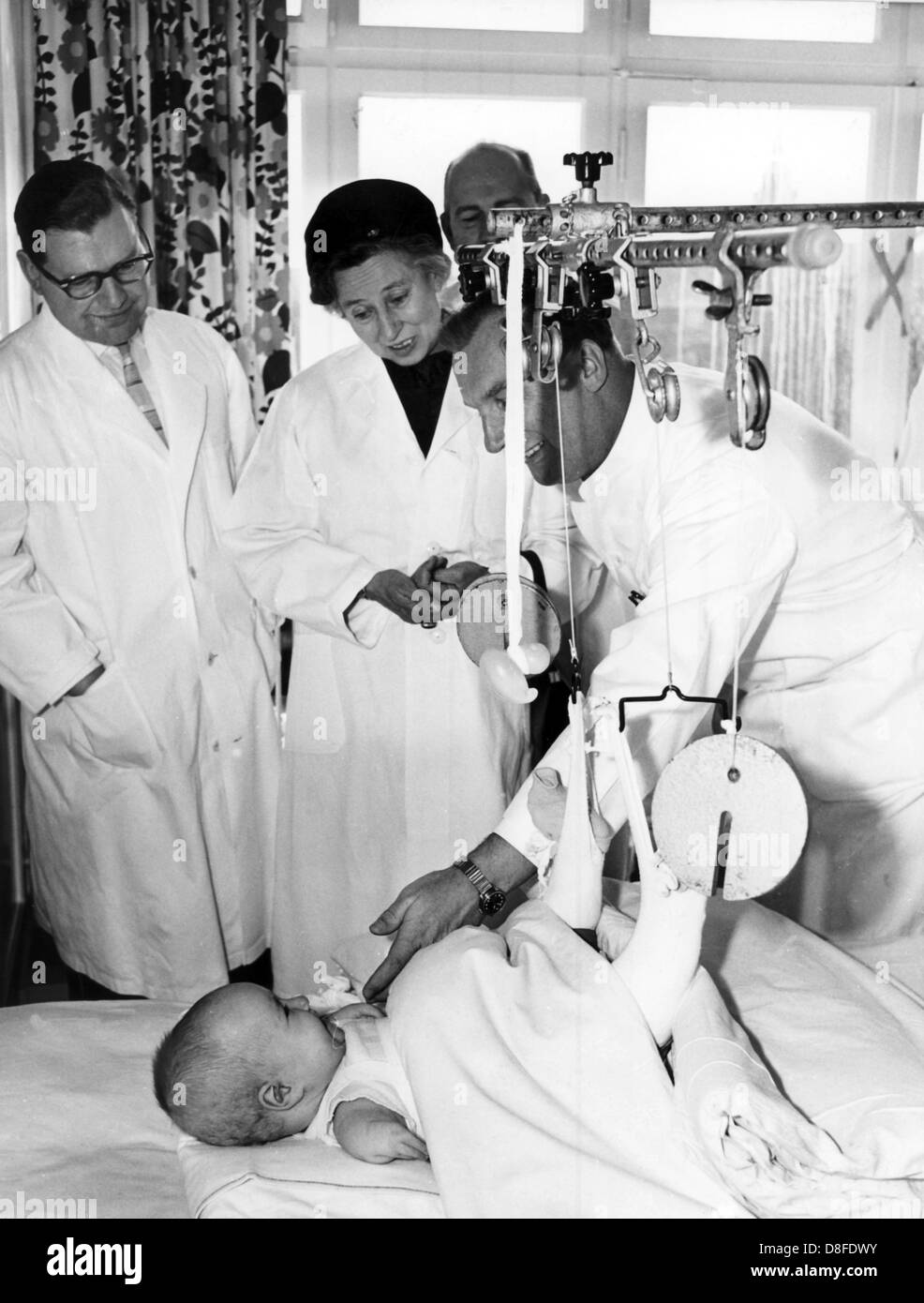 German health minister Elisabeth Schwarzhaupt (c) visits Contergan affected children at the dysmelia ward of the the 'Anna-Stift' hospital in Hanover, Germany, 2 April 1963. To her right stands Professor Dr. Gustav Hauberg, head physician of the hospital. Stock Photo