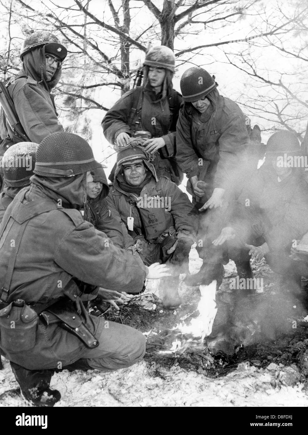 Soldiers of the US army warm themselves up at the fire during a routine winter exercise in Grunewald in Berlin on the 23rd of January in 1963. Stock Photo