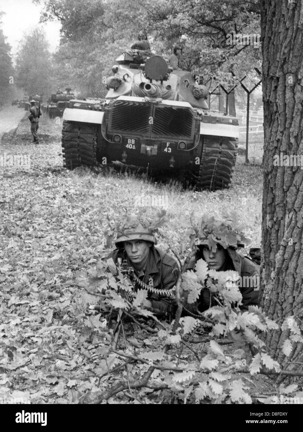 Camouflaged soldiers of the US army in front of a tank during an ...