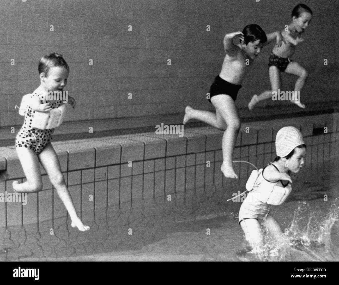 Disabled children, some wearing flotation devices some don't, jump