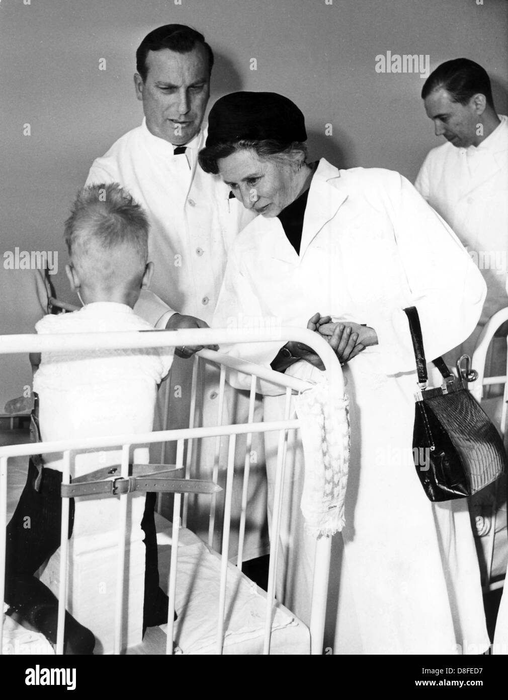 German health minister Elisabeth Schwarzhaupt visits Contergan affected children at the dysmelia ward of the the 'Anna-Stift' hospital in Hanover, Germany, 2 April 1963. To her left stands Professor Dr. Gustav Hauberg, head physician of the hospital. Stock Photo