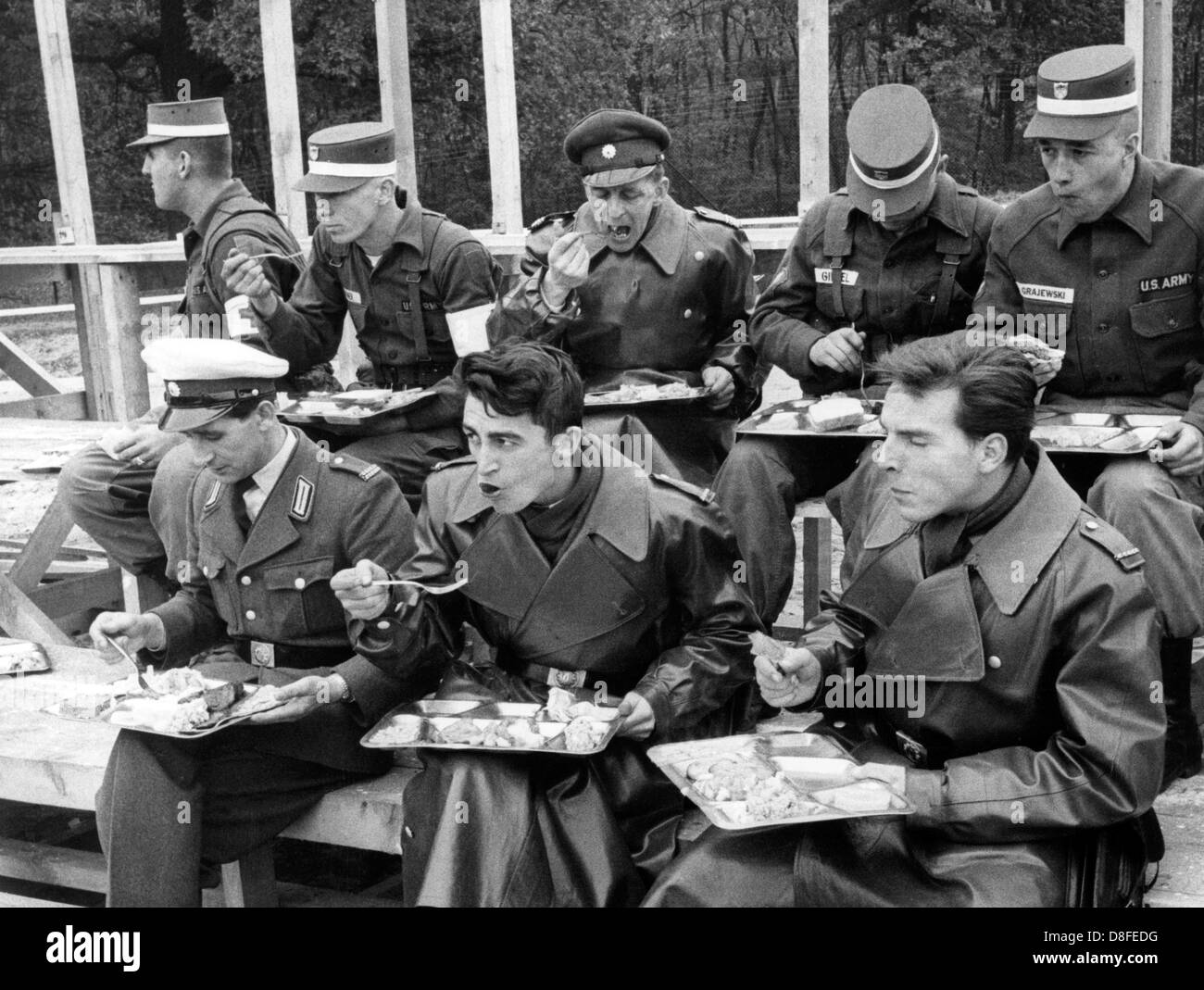 Soldiers of the US army have their meal together with police men of West Berlin shortly before the beginning of the field exercise on the 23rd of October in 1962 on the US artillerey range Keerans Range in Grunewald in Berlin. The exercise was part of a four day manoeuvre of the US troops. Stock Photo