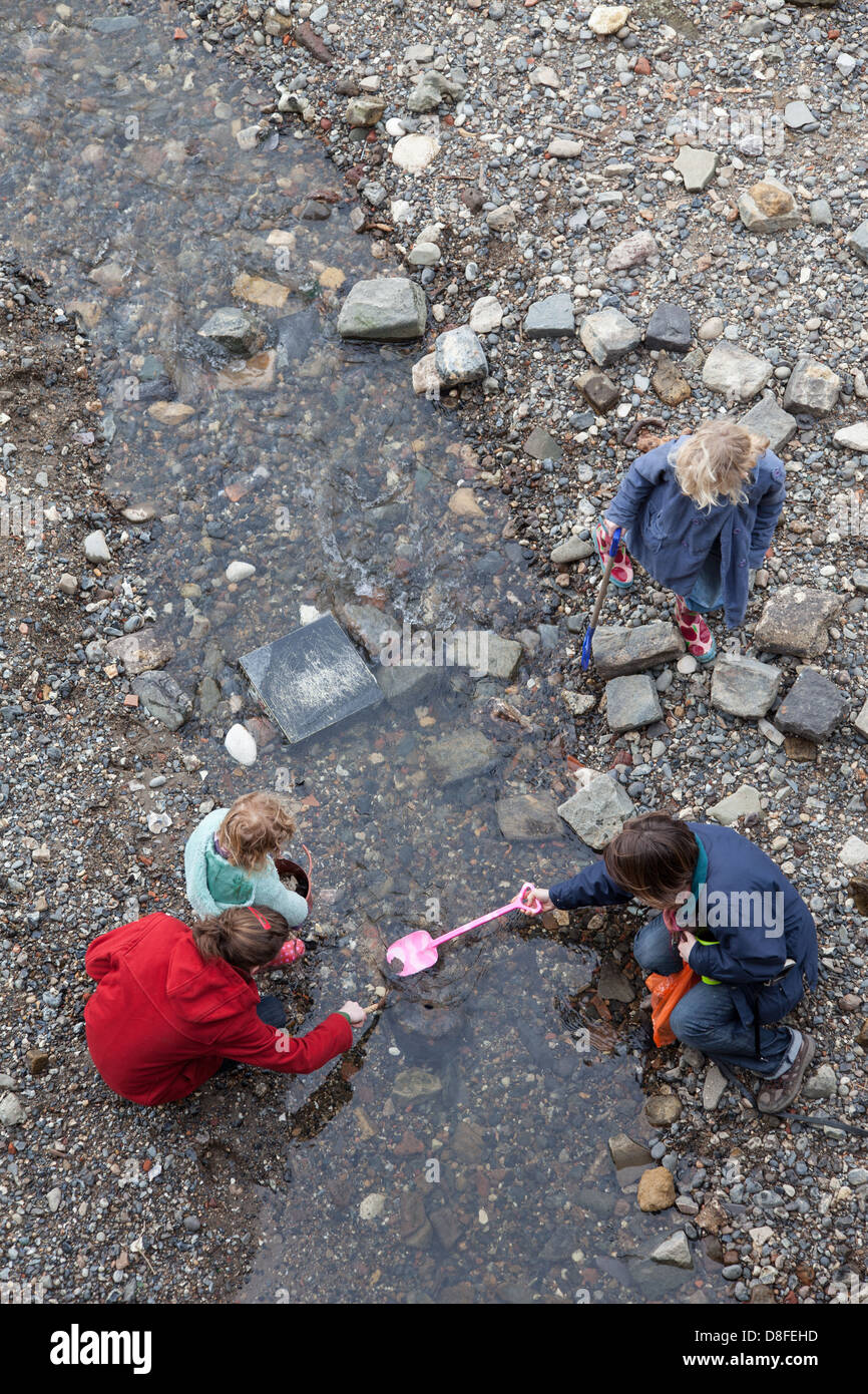 Mother and children mudlarking on Thames foreshore Stock Photo