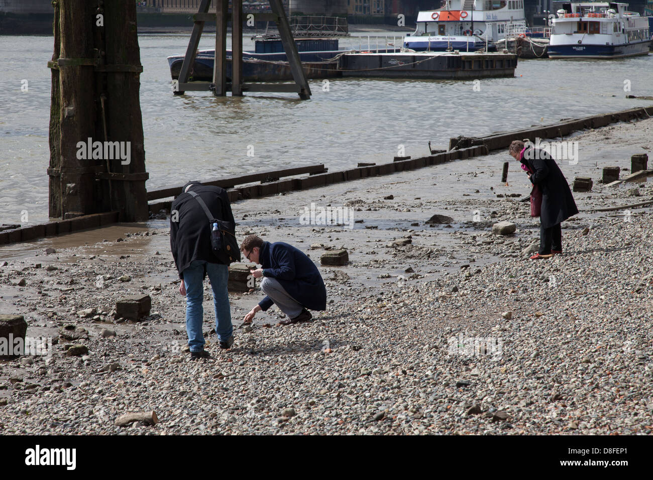 People mudlarking on foreshore at low tide, River Thames, London Stock Photo