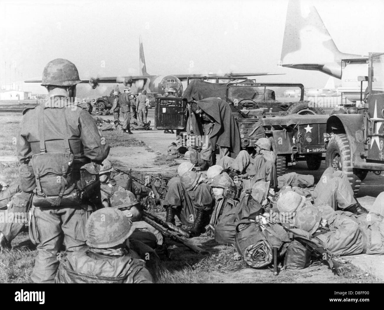 American soldiers wait for the beginning of the large airborne manoeuvre 'South Arrow' at the air base in Frankfurt am Main on the 1st of May in 1966. In the background the Herkules transport machines. Stock Photo