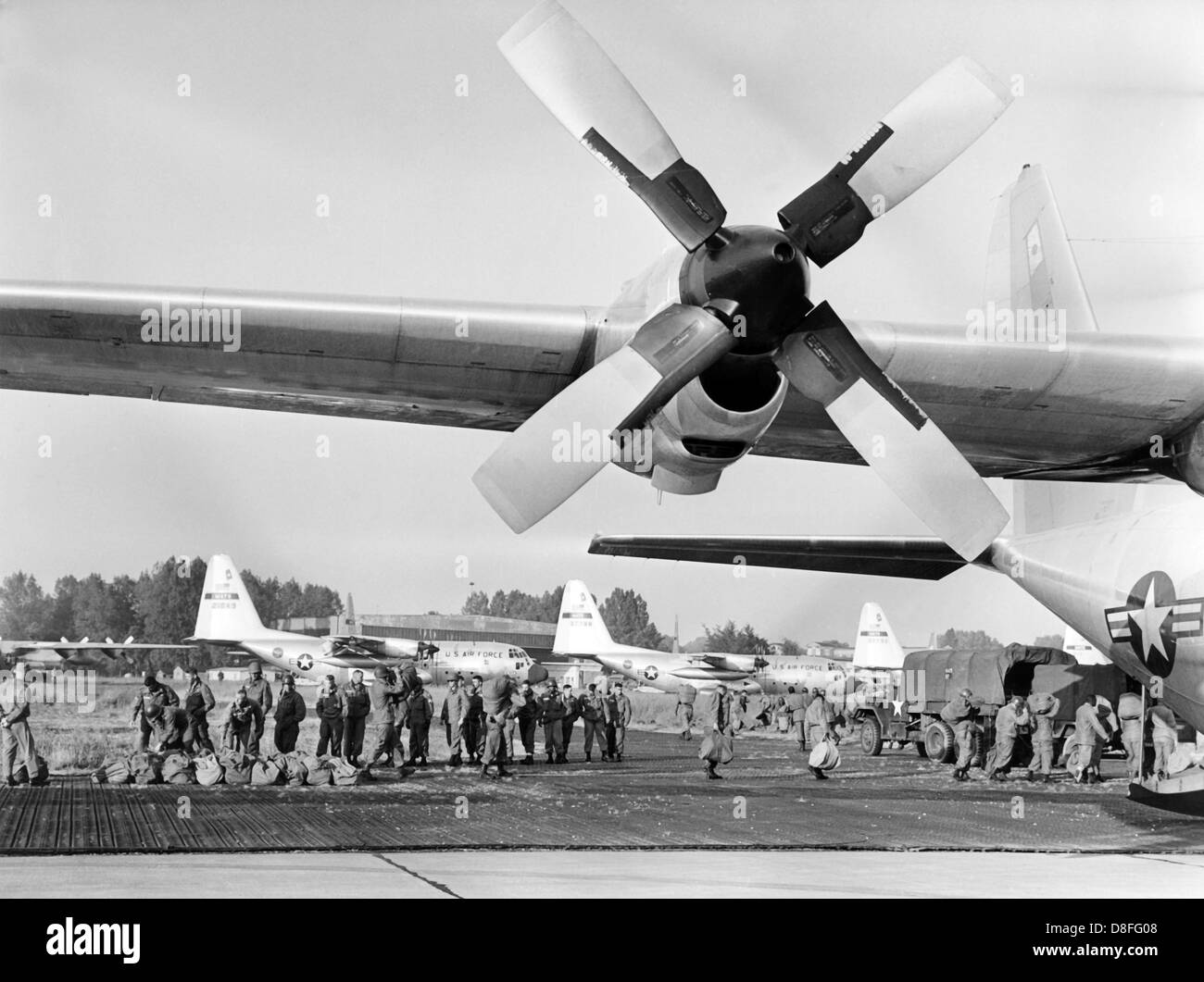 Crew and devices of the US army are loaded into transport machines of the type C-130 'Hercules' in Erding on the 10th of June in 1964. They are part of the airborne exercise 'Northwind', in which roughly 2,000 paratroopers will jump off above the operational area. Stock Photo