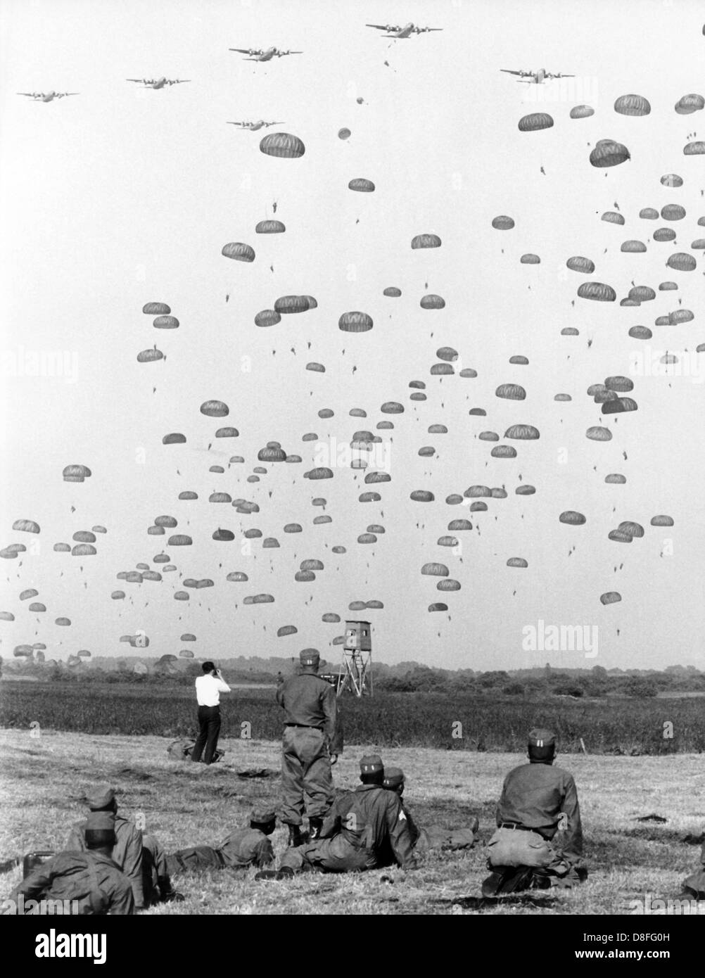 The soldiers of the 8th US infantry division levitate onto the ground like a swarm of bees on the 10th of June in 1964 near Günzburg in Bavaria. More than 2,000 paratroopers jumped off from 48 four-engined machines of the type C-130 'Hercules' above the operational area within the manoeuvre 'Northwind'. Stock Photo