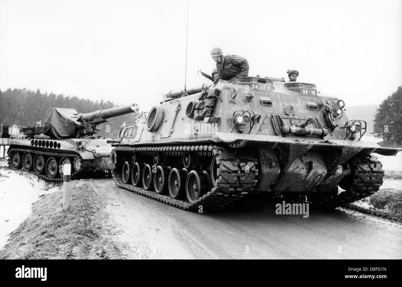 An armored tank of the US army is pulling a self-propelled artillery vehicle during the NATO maneuver REFORGER I - 'Return of Forces to Germany', on 30th January 1969 near Grafenwöhr, Bavaria. Stock Photo