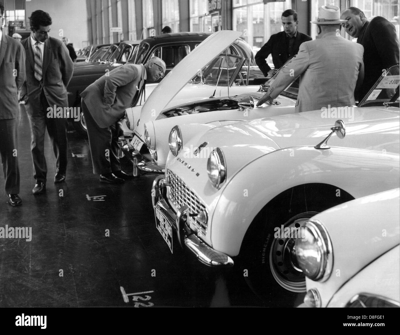 Visitors check second-hand sports cars in a cheaper price category. The annual second-hand car market at Killesberg in Stuttgart starts on the 14th of September in 1962. Stock Photo