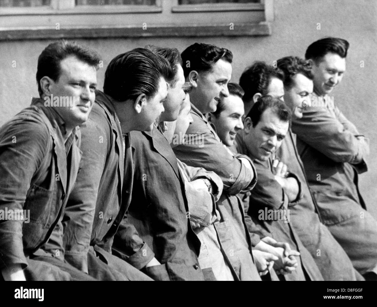 A group of employees takes the chance of the nice spring weather in March to have a break outside. Picture from March 1961. Stock Photo