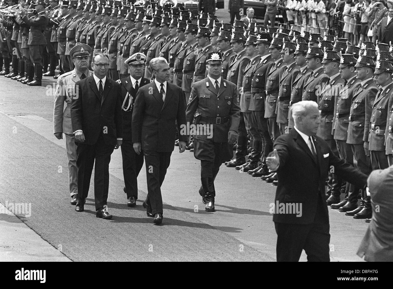 Iranian Shah Reza Mohammed Pahlavi (m) and governing mayor of Berlin Heinrich Albertz (l) walk past an honorary formation of the police of Berlin on the 2nd of June in 1967 in airport of Tempelhof in Berlin. The visit of the Shah caused massive protests, during which student Benno Ohnesorg lost his life. Stock Photo