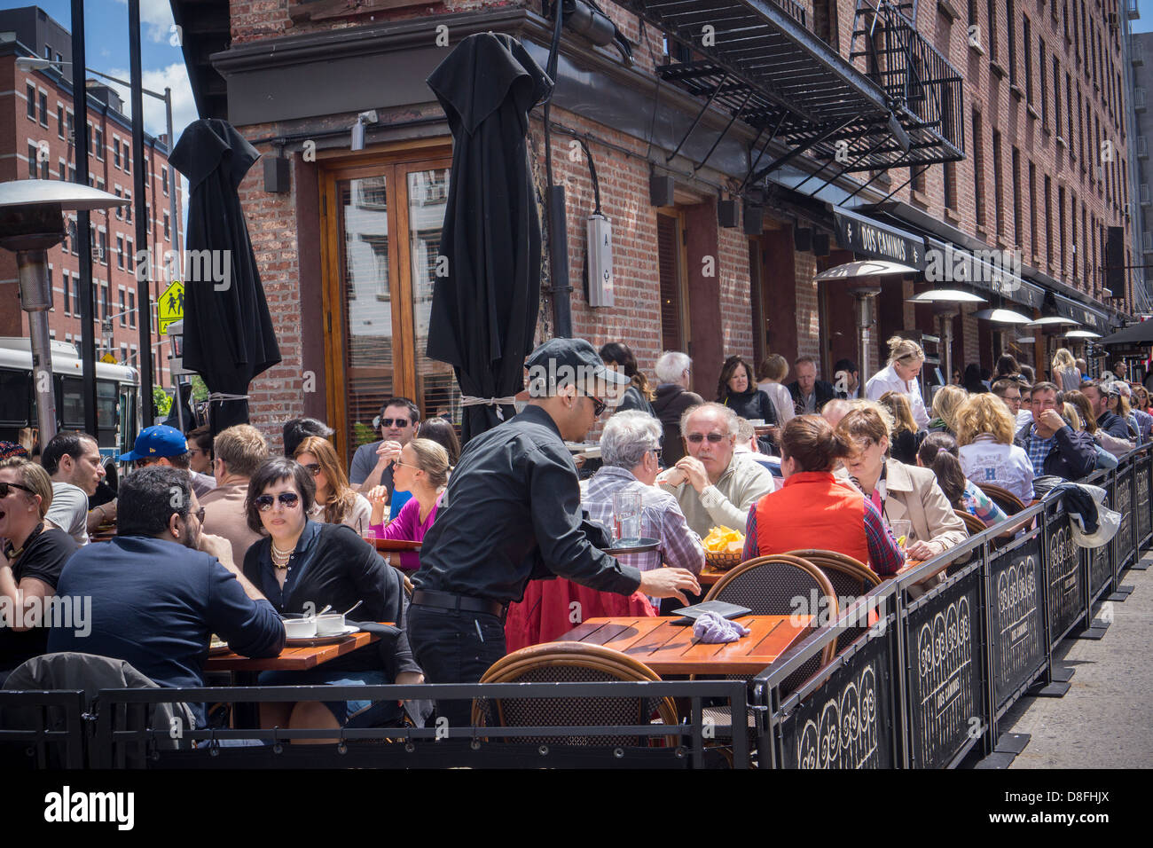 Busy al fresco dining at sidewalk cafes in the Meatpacking District in New York on Sunday, May 26, 2013. (© Richard B. Levine) Stock Photo
