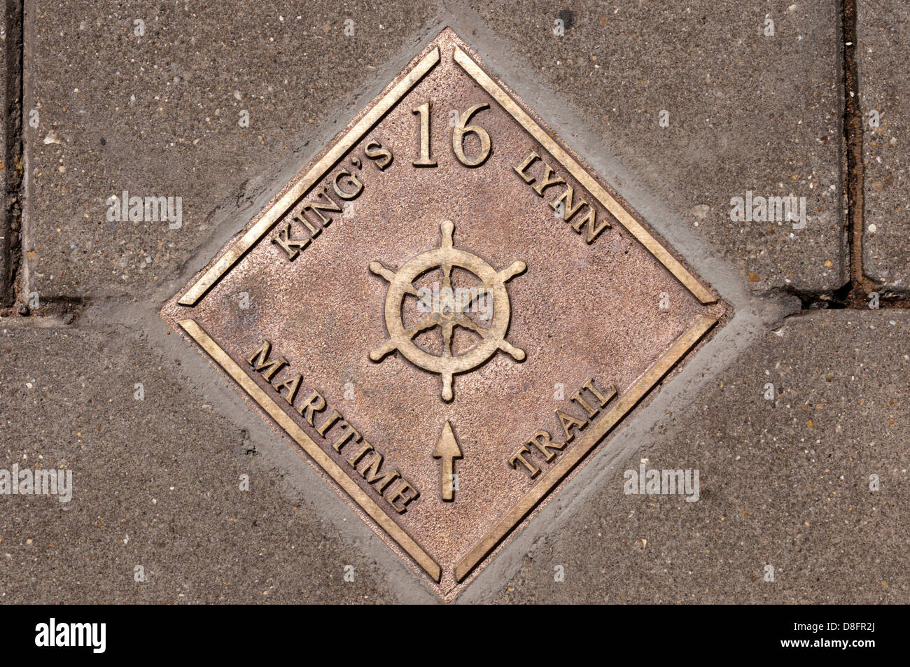 A metal stud in the pavement marks the route of the King's Lynn Maritime Trail. Stock Photo