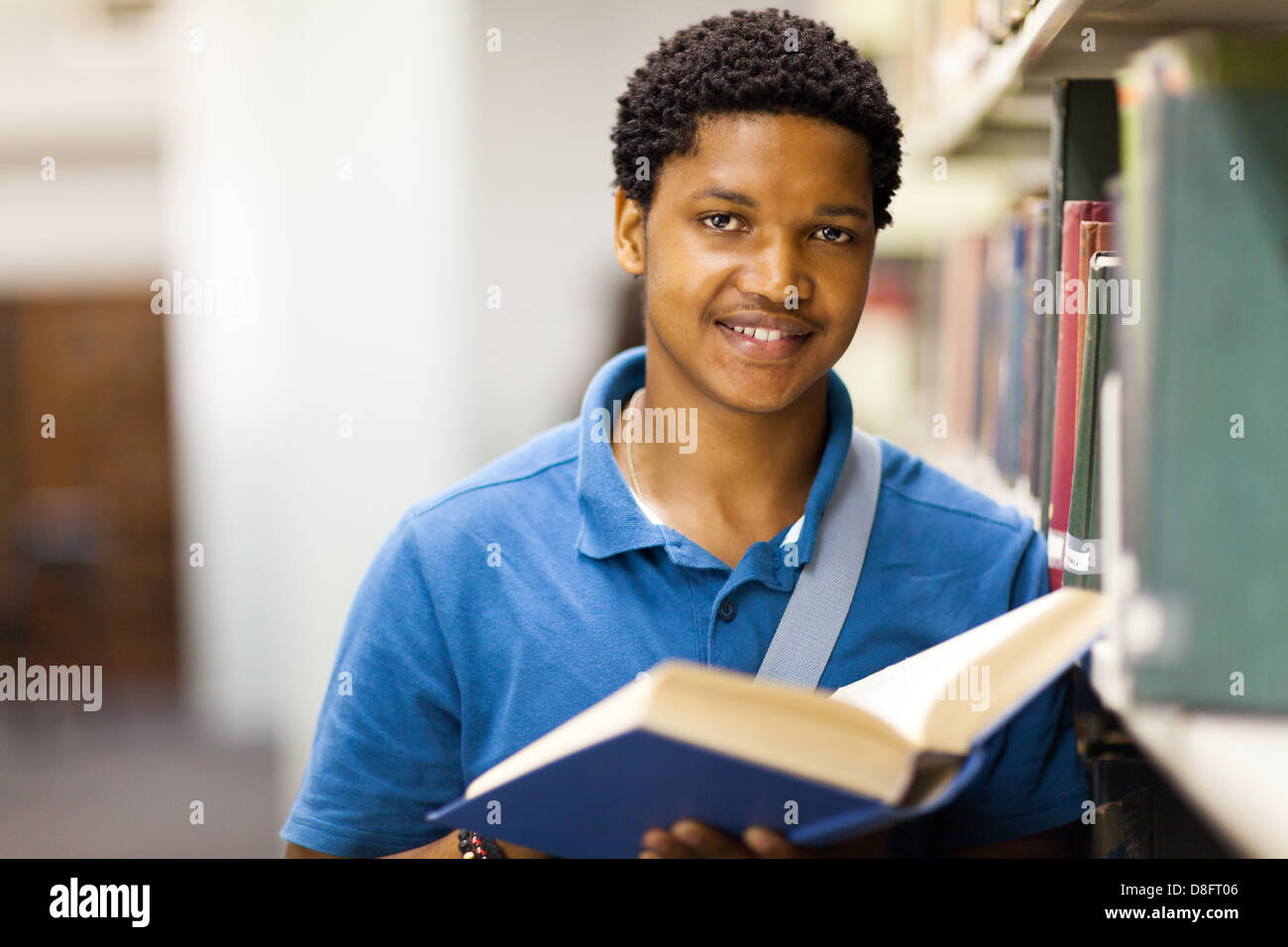 male African American college student reading book in library Stock Photo