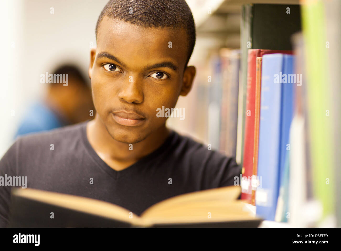 male African American college student reading in library Stock Photo