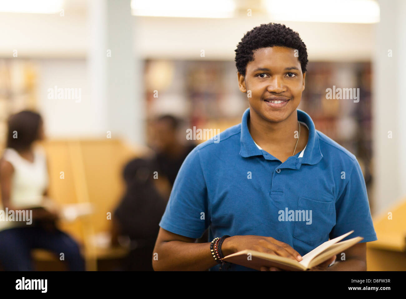 male African American college student reading book in library Stock Photo