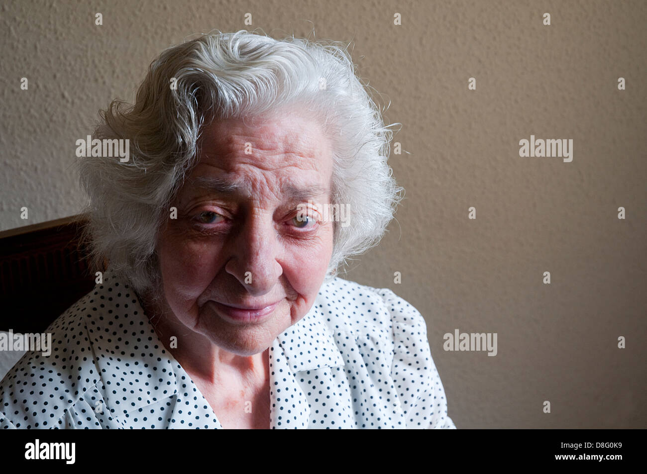 Portrait of elderly woman at home, smiling and looking at the camera. Stock Photo