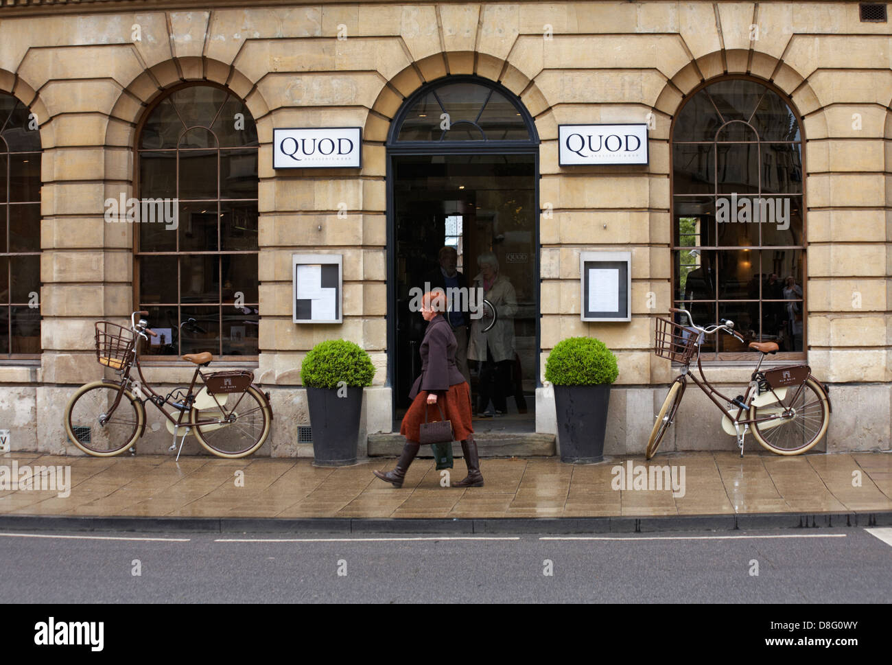 woman walking past Quod Brasserie & Bar at Oxford, Oxfordshire UK in May Stock Photo