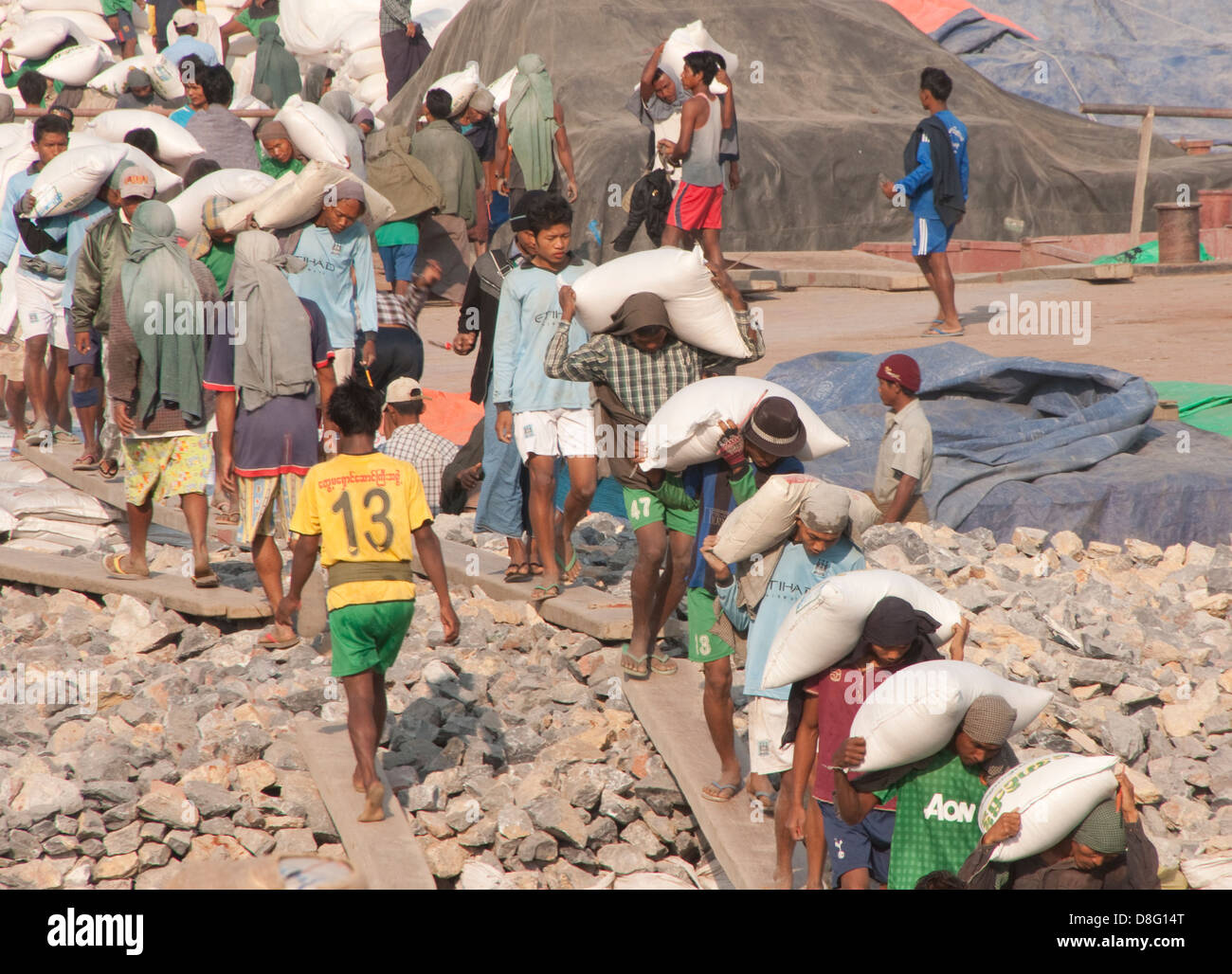 Laborers unloading barge on Ayeyarwaddy River near Mandalay, Myanmar. Stock Photo