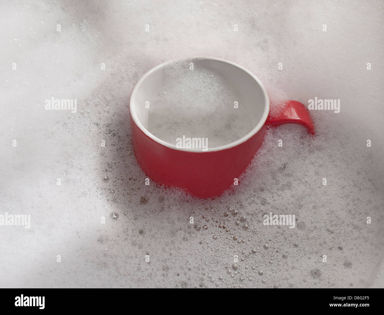 red mug in soap suds Stock Photo
