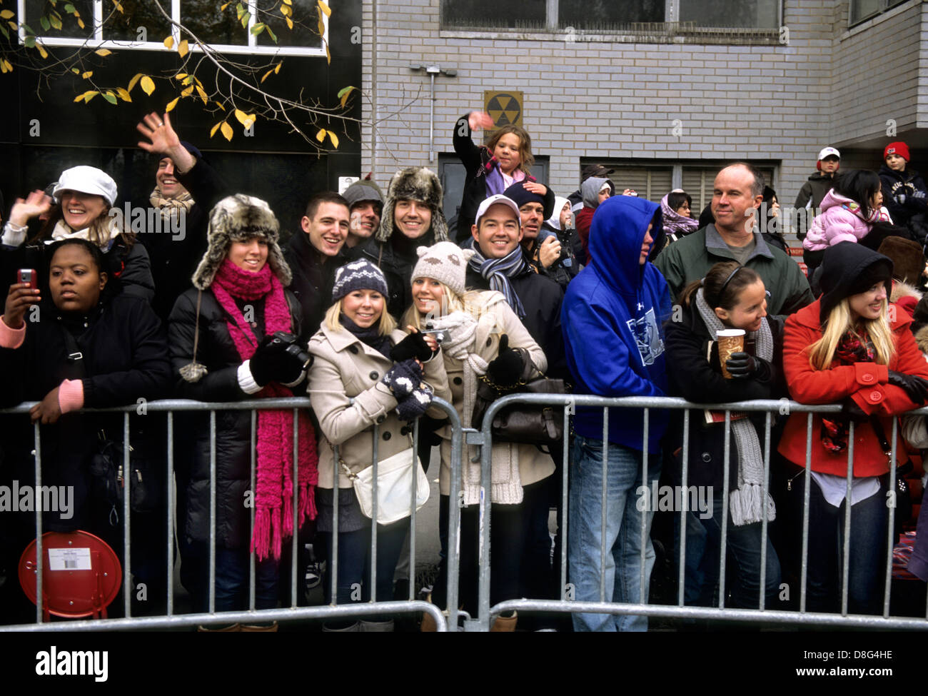 New York City crowded street. Group of people watching Macy's Thanksgiving Day Parade behind barrier in Midtown Manhattan. Close-up Stock Photo