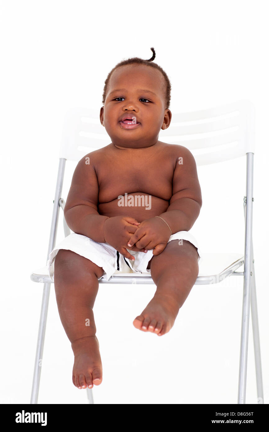cute African baby boy sitting on white chair Stock Photo